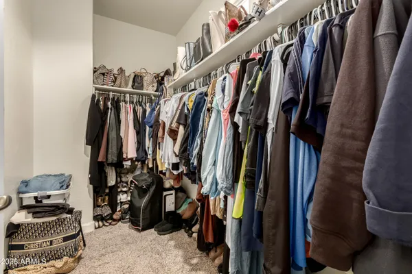 a view of walk in closet with clothes and shoes