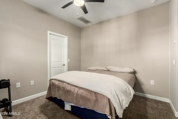 a bedroom with a bed and a ceiling fan