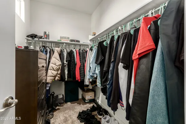 a view of walk in closet with clothes