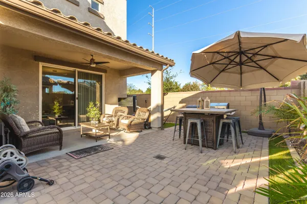 a view of a patio with dining table and chairs under an umbrella