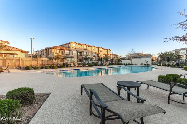a swimming pool with outdoor seating and lake view