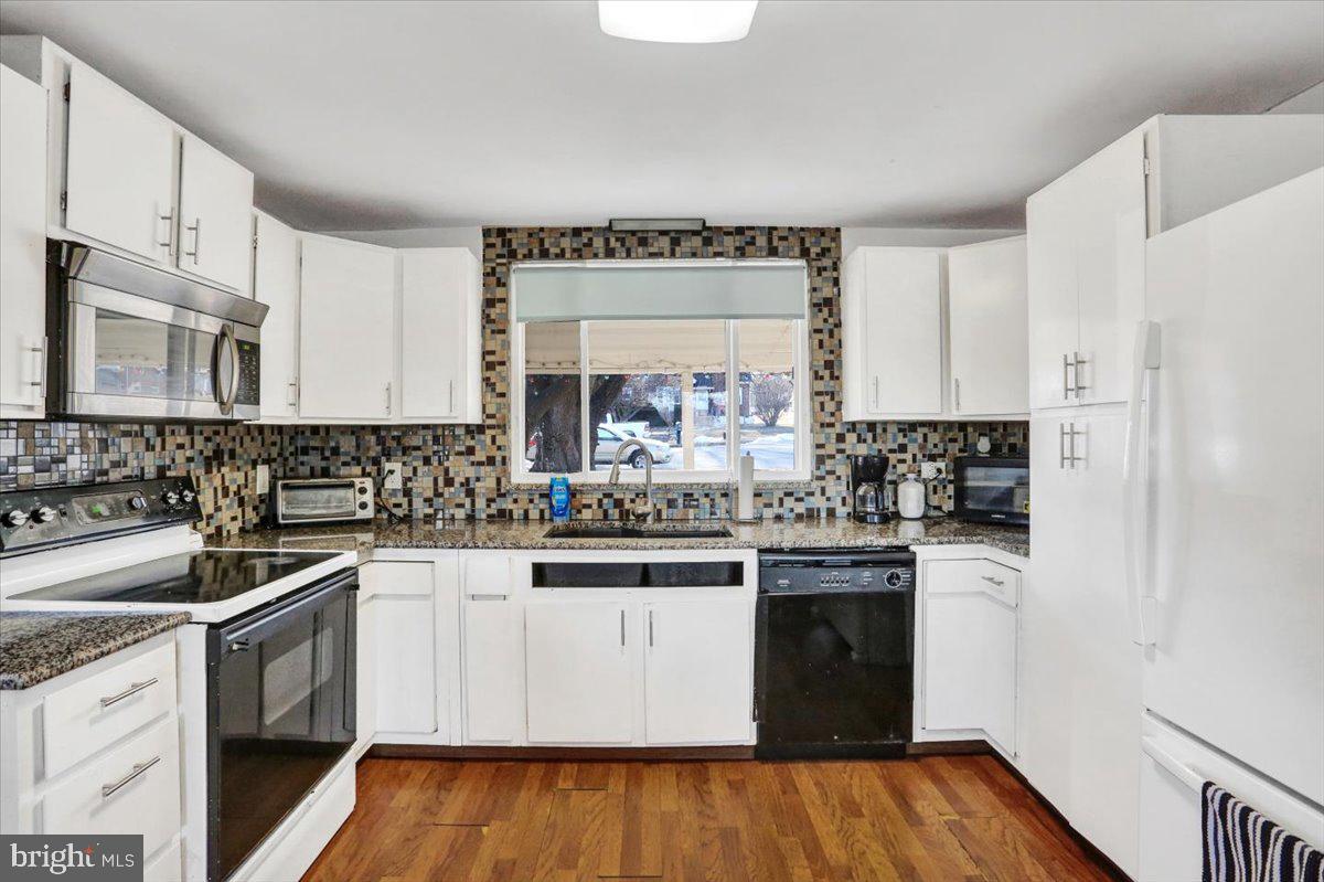 321 Pershing Boulevard Reading, PA 19607 - Photo 13 of 36 a kitchen with stainless steel appliances granite countertop a sink and cabinets with wooden floors