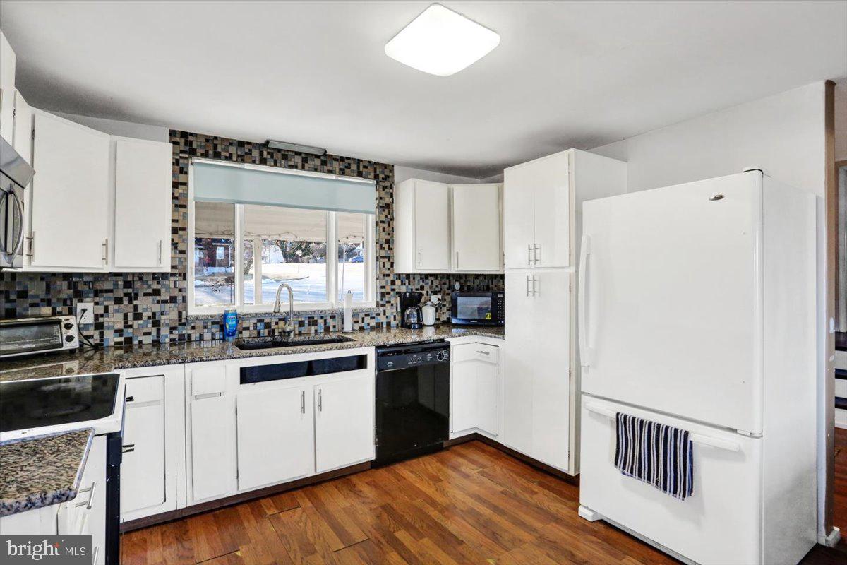 321 Pershing Boulevard Reading, PA 19607 - Photo 14 of 36 a kitchen with granite countertop white cabinets and white appliances