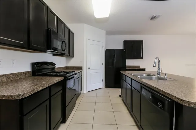 a kitchen with stainless steel appliances granite countertop a stove a sink dishwasher and a refrigerator