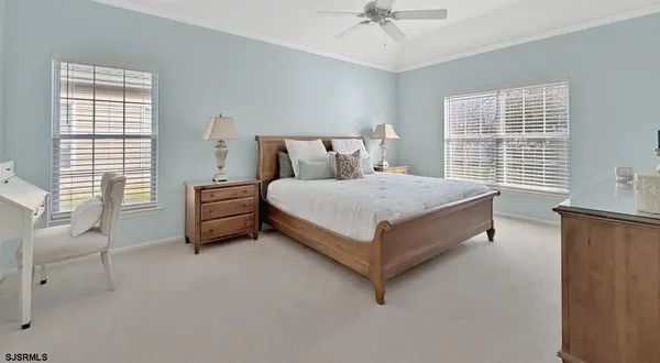 a bedroom with a bed couch and windows