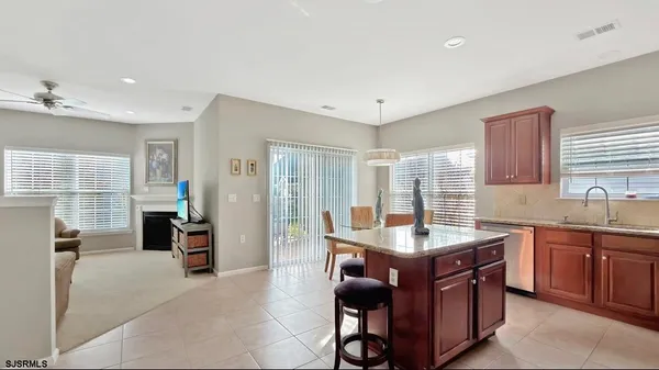 a kitchen with granite countertop a sink and dishwasher with a dining table