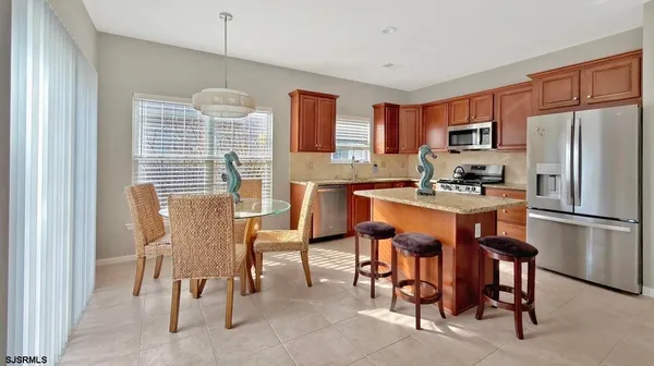 a kitchen with a refrigerator a table and chairs in it