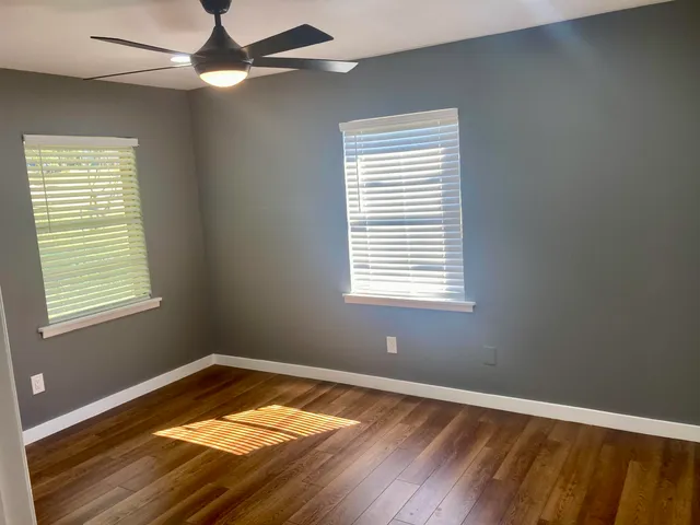 a view of a room with wooden floor and windows