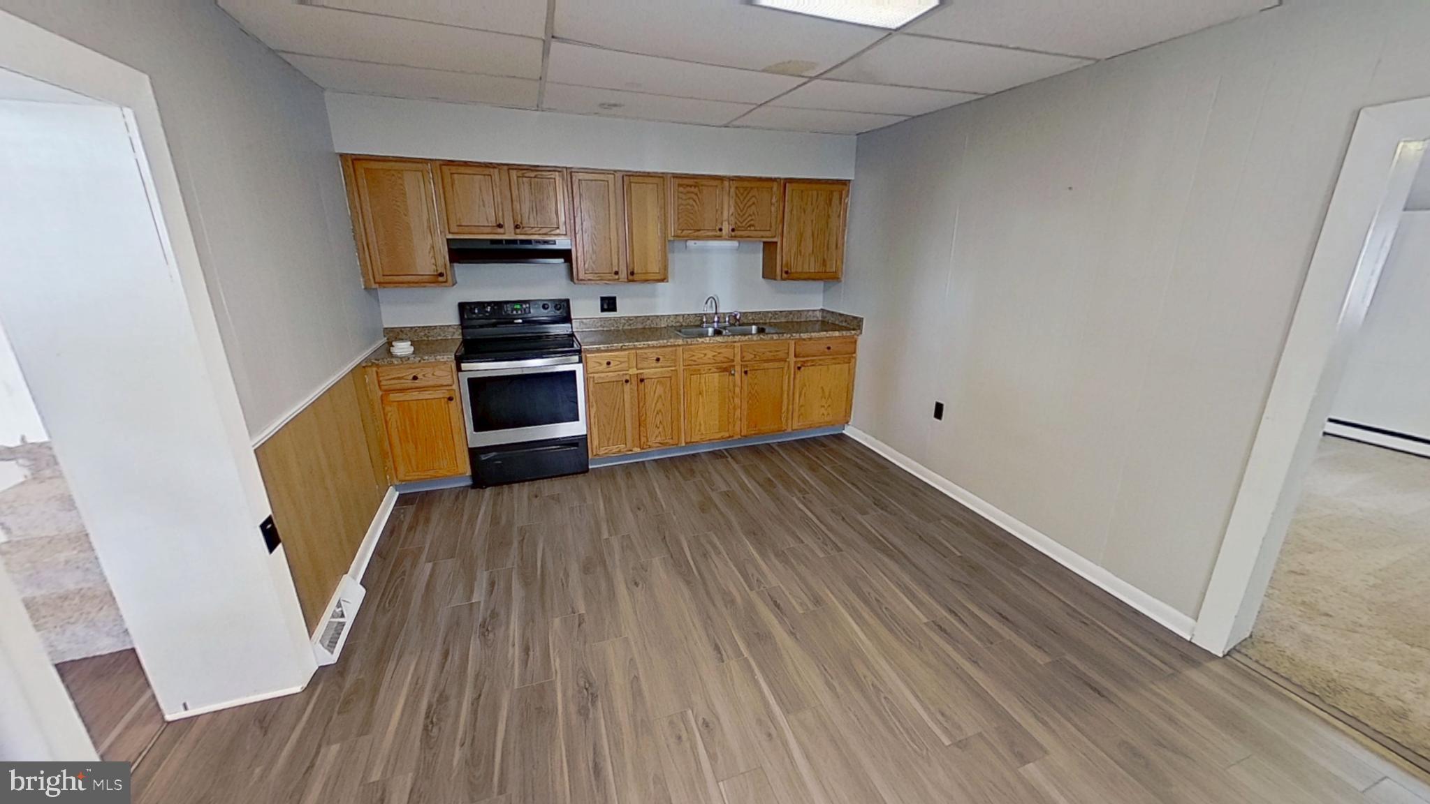 648 Broadway, Unit B Hanover, PA 17331 - Photo 12 of 12 a kitchen with granite countertop wooden floors stainless steel appliances a sink and a window