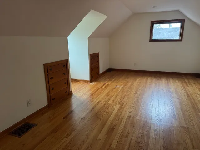 a view of a room with wooden floor and window