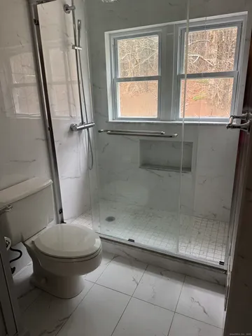 a bathroom with a toilet and a shower