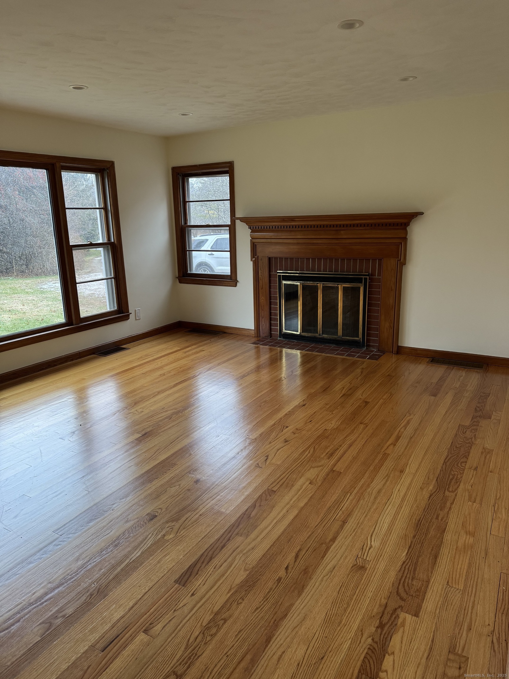 85 Mountain Road Norfolk, CT 06058 - Photo 6 of 15 a view of a livingroom with wooden floor and a fireplace