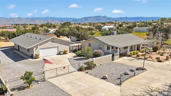 an aerial view of a house with yard and mountain view in back