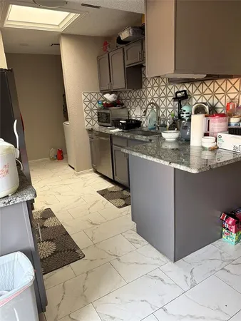 a kitchen with stainless steel appliances kitchen island granite countertop a sink stove and cabinets