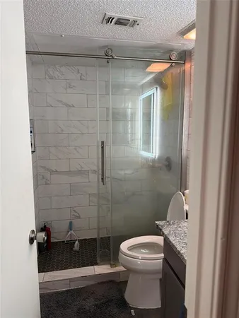 a bathroom with a toilet and a shower