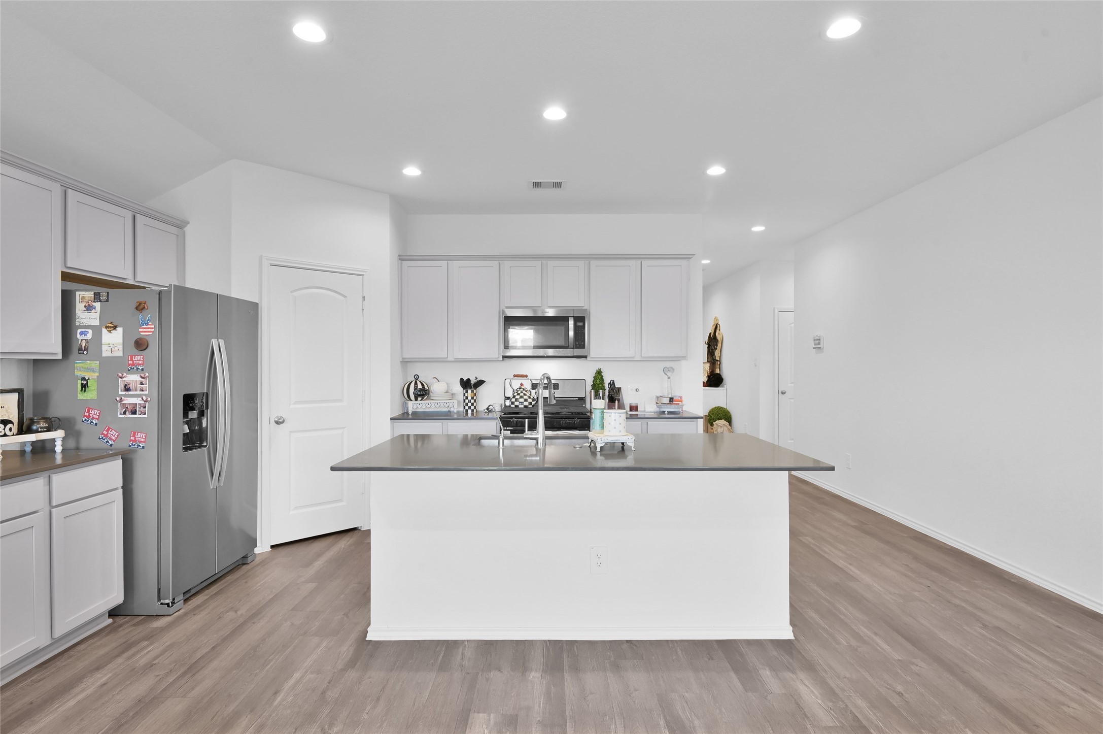 12369 Carib Crossing Lane Conroe, TX 77304 - Photo 11 of 43 a view of kitchen with stainless steel appliances granite countertop a stove a refrigerator a sink and a refrigerator with wooden floor