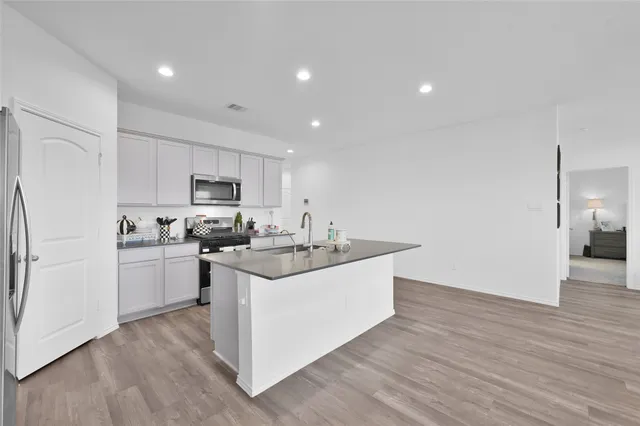 a kitchen with sink stove and refrigerator