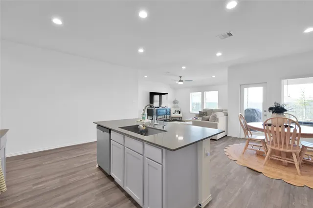 a kitchen with sink stove and wooden floor
