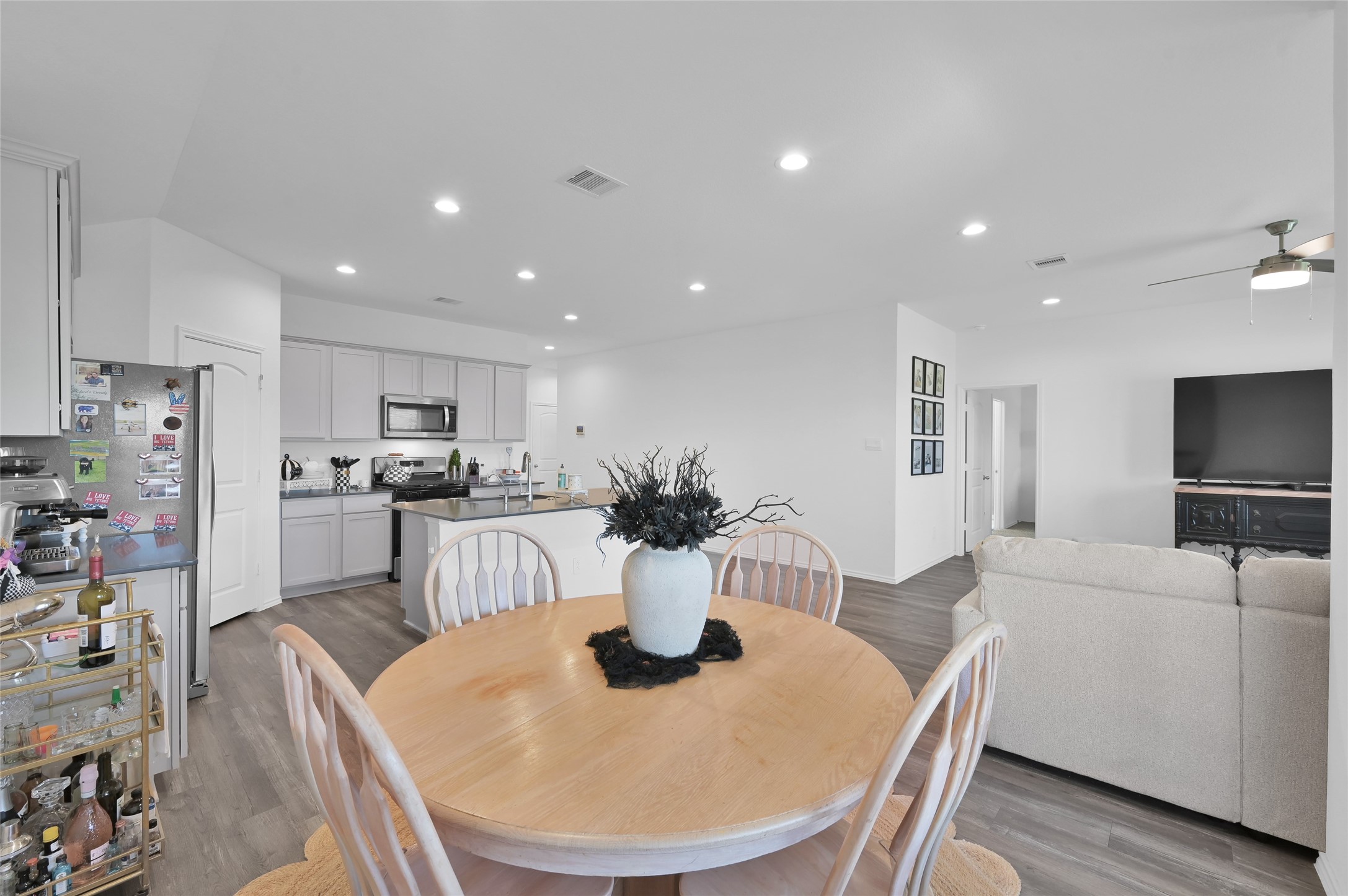 12369 Carib Crossing Lane Conroe, TX 77304 - Photo 18 of 43 a kitchen with a dining table chairs and refrigerator