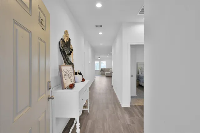 a view of a hallway with wooden floor and stairs