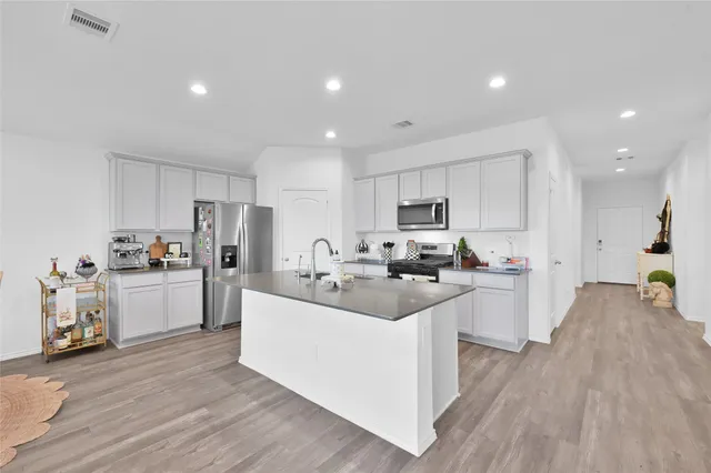 a kitchen with refrigerator a sink and cabinets