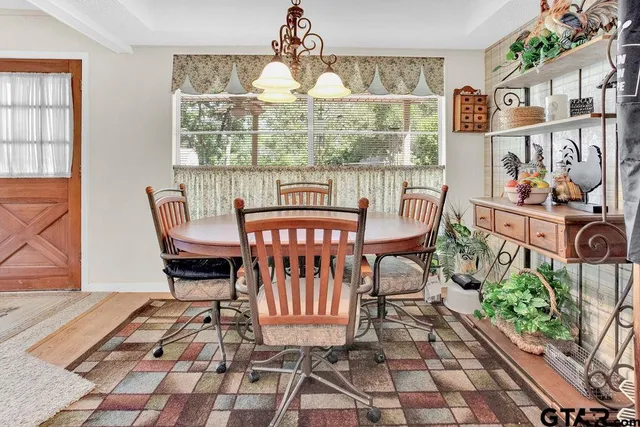 a view of a dining room with furniture a rug and wooden floor