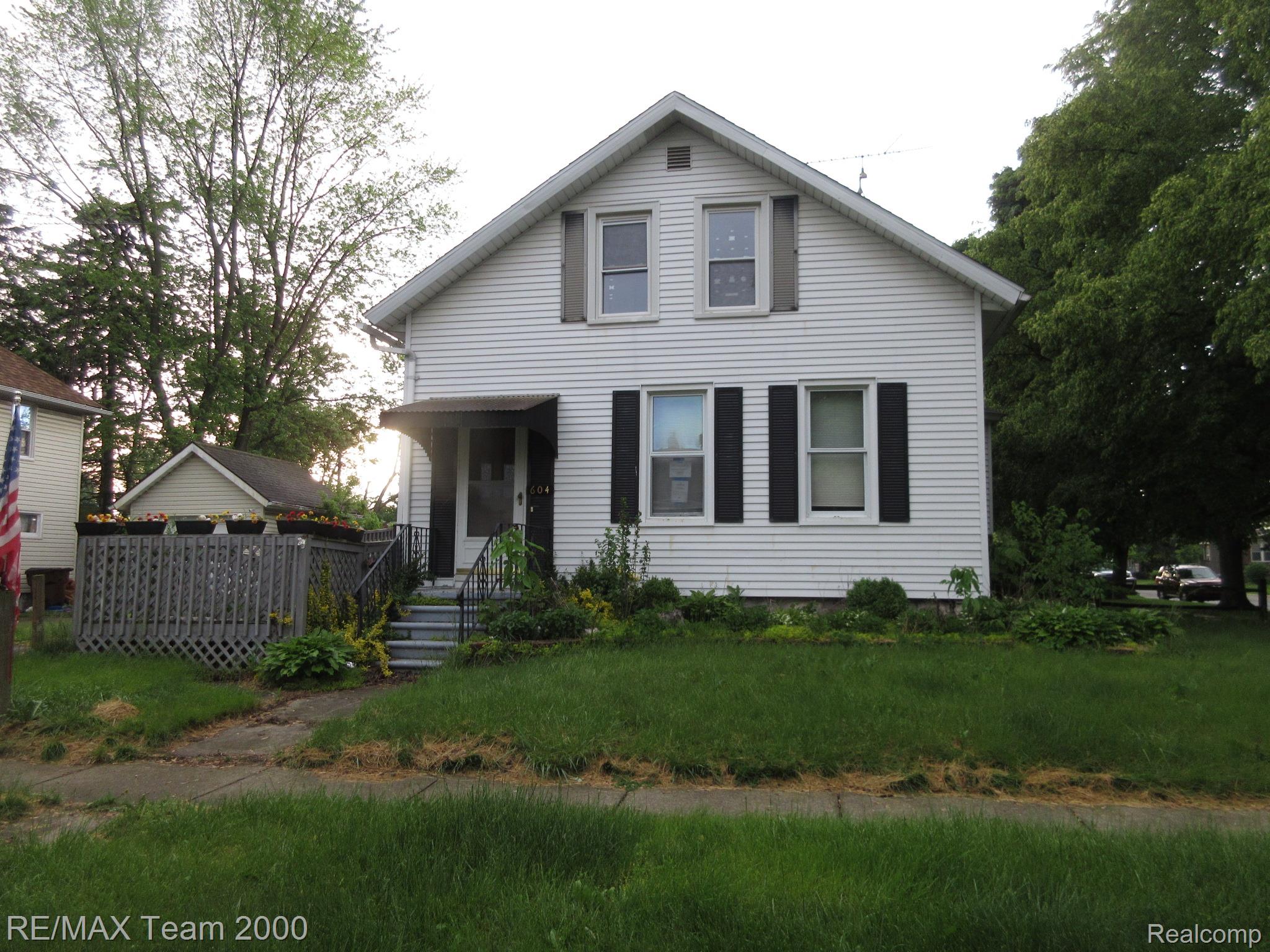 604 Smith Street Monroe, MI 48161 - Photo 1 of 24 Two-story residence featuring white siding, dark shutters, and a covered entry