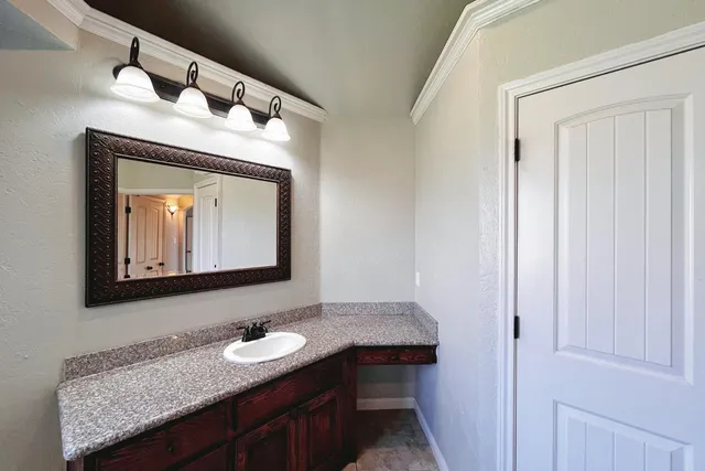 a bathroom with a granite countertop sink and a mirror