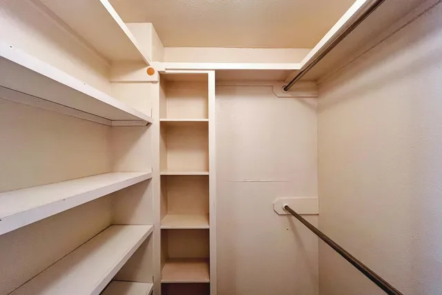 a view of walk in closet with empty racks