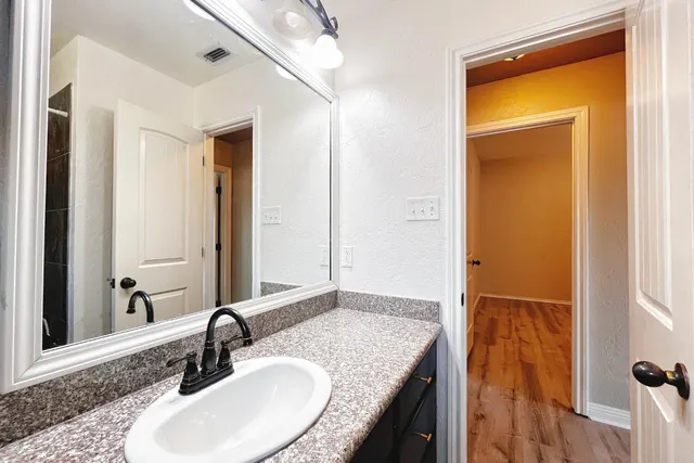 a bathroom with a granite countertop sink and a mirror