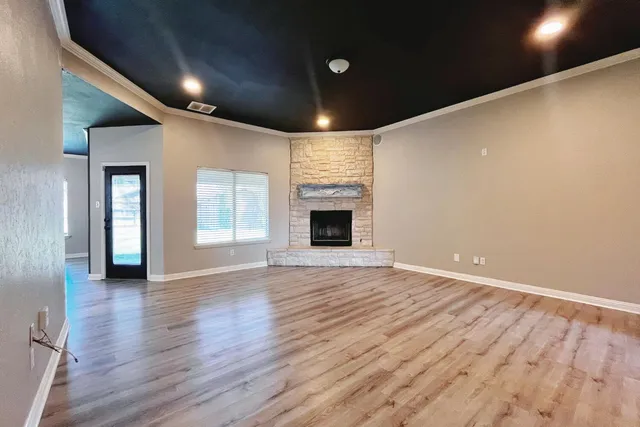 an empty room with wooden floor and fireplace
