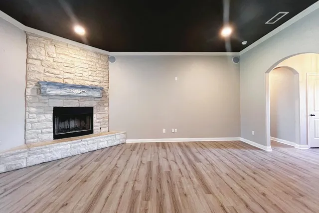 an empty room with wooden floor and fireplace