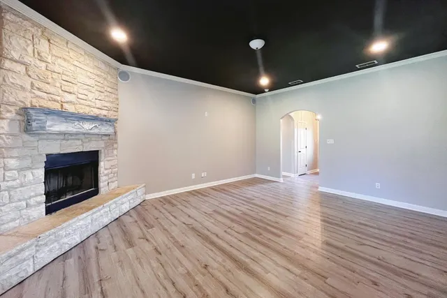 an empty room with wooden floor and fireplace