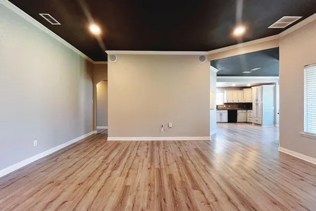 an empty room with wooden floor and a window