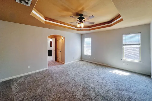 a view of an empty room with a chandelier fan