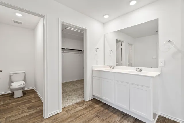 a kitchen with stainless steel appliances granite countertop a stove top oven a sink a refrigerator and white cabinets