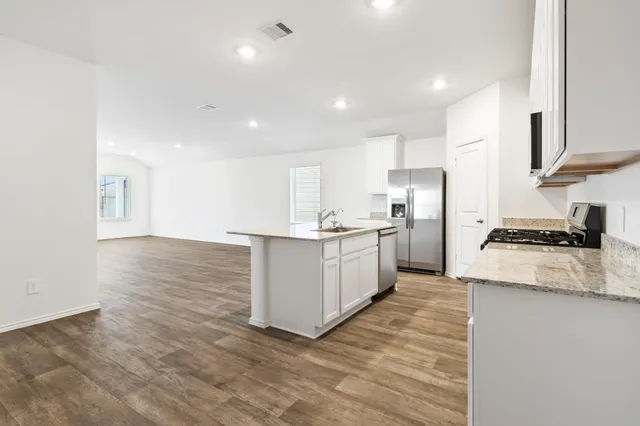 a kitchen with stainless steel appliances granite countertop a sink stove and refrigerator