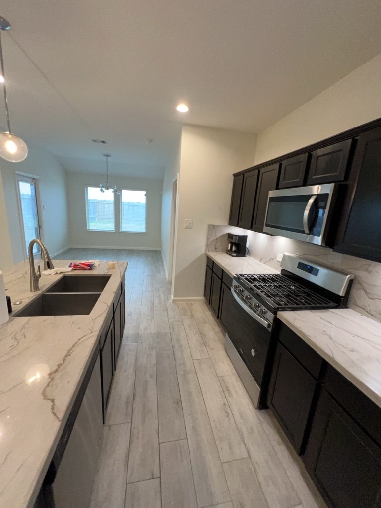 5327 Cherry Tallow Trail Katy, TX 77449 - Photo 5 of 18 a kitchen with stainless steel appliances granite countertop a stove and a sink