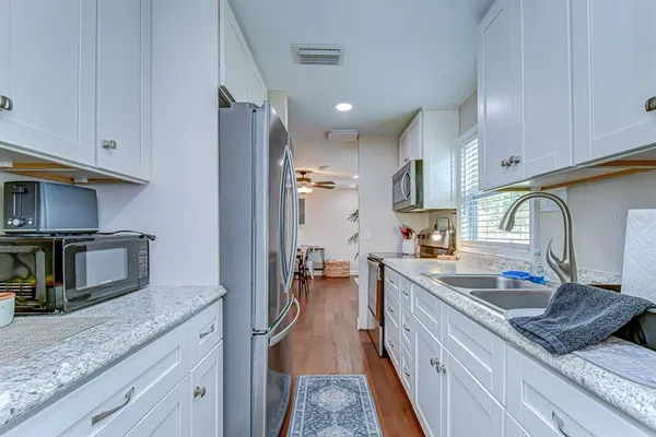a kitchen with granite countertop a sink stainless steel appliances and cabinets