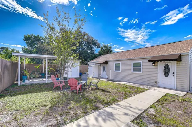 a view of a house with backyard and sitting area