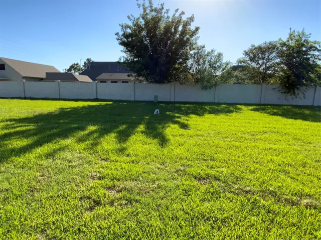 a view of a yard with a house in the background