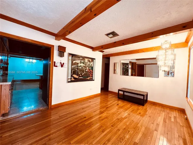 a view of a living room with wooden floor and furniture
