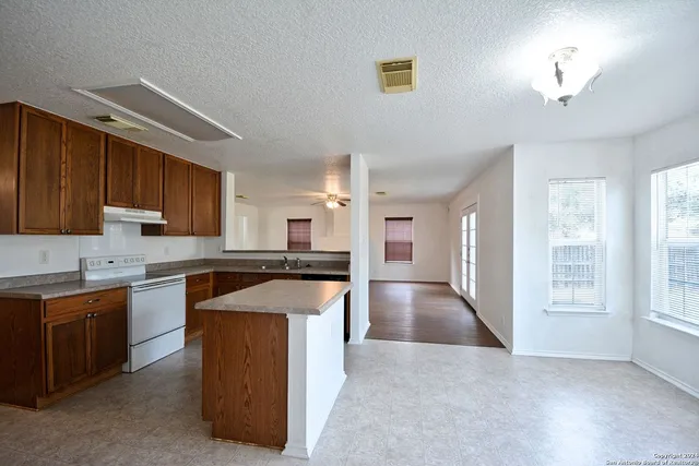 a kitchen with a stove sink and cabinets