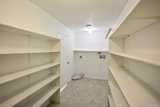 a view of walk in closet with empty racks