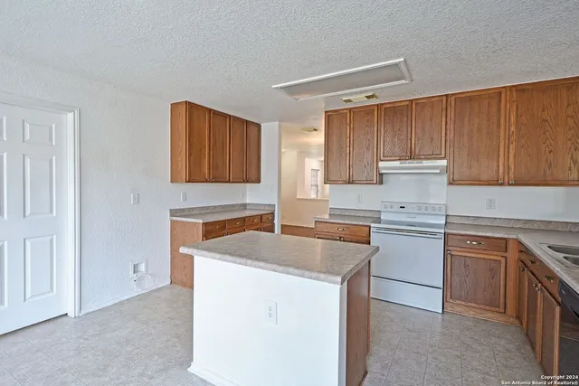 a kitchen with a sink stove and cabinets