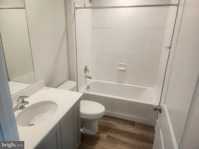 a white toilet sitting next to a bath tub
