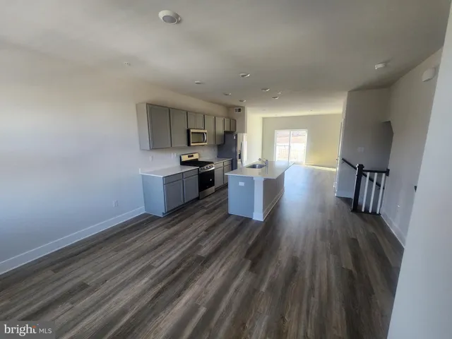 a kitchen with stainless steel appliances a sink a stove a refrigerator and cabinets
