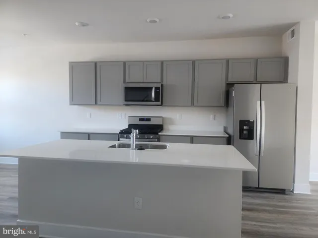 a kitchen with appliances a sink and cabinets