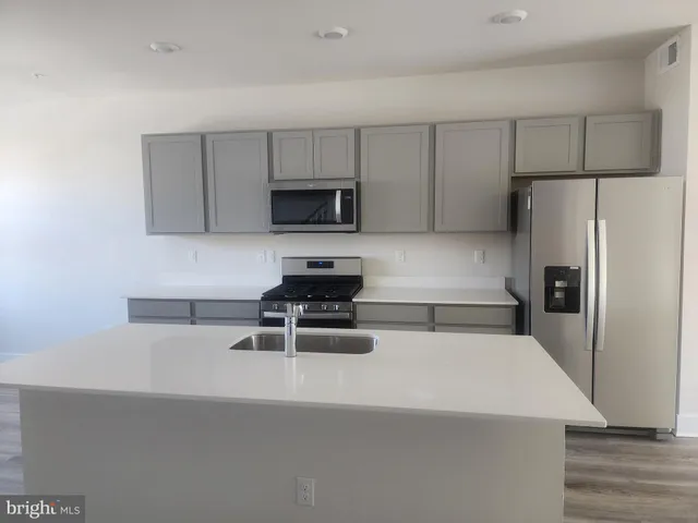 a kitchen with a refrigerator a stove a microwave a sink and cabinets