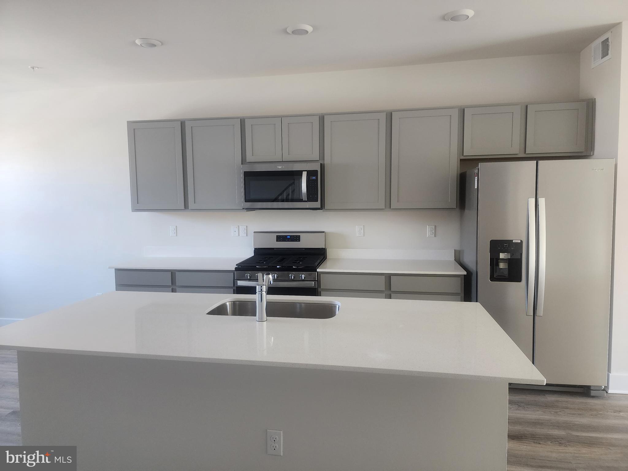 231 Joppa Farm Road Joppa, MD 21085 - Photo 7 of 25 a kitchen with a refrigerator a stove a microwave a sink and cabinets